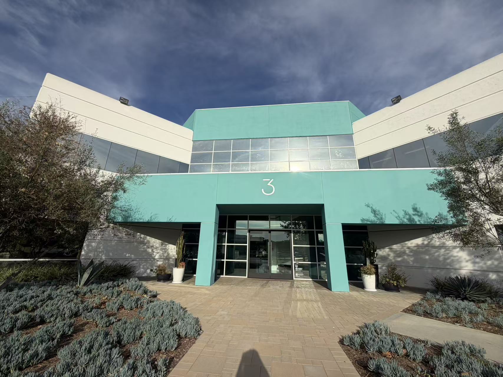 A professional exterior view of a modern two-story office building at 3 Corporate Park in Irvine, California